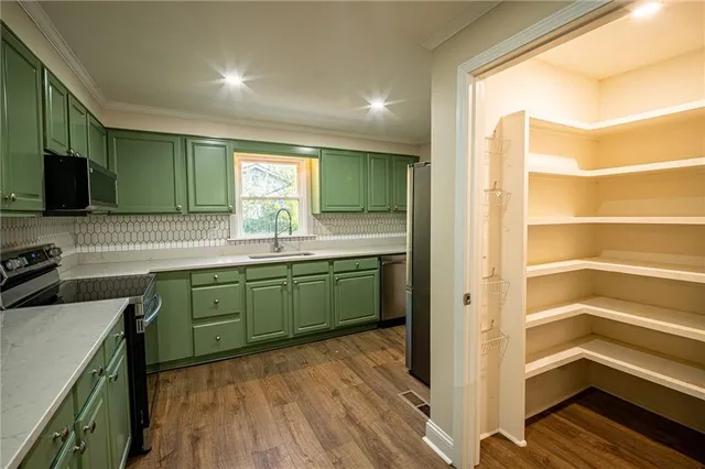 a kitchen with a sink cabinets and wooden floor