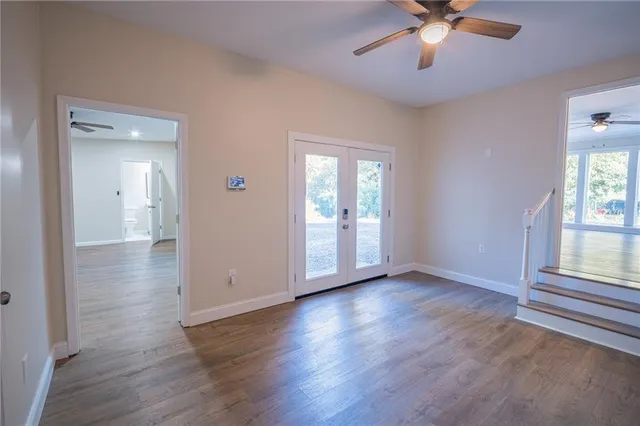 an empty room with wooden floor and windows