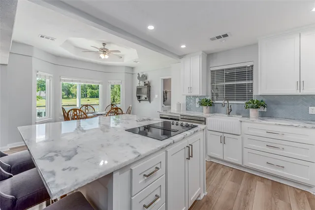 a kitchen with granite countertop a sink and white cabinets