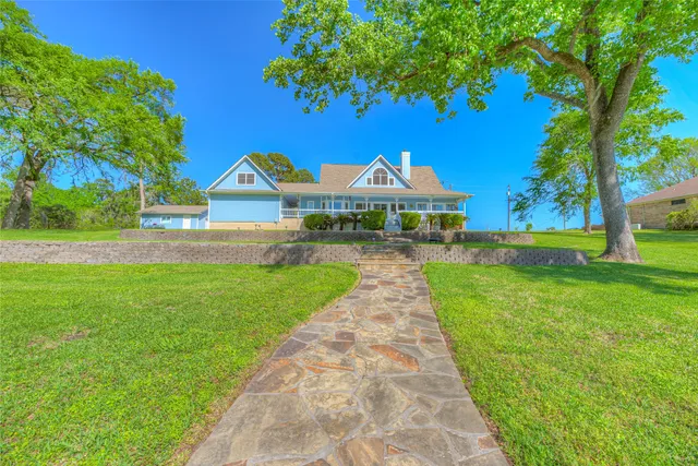 a front view of a house with yard and green space