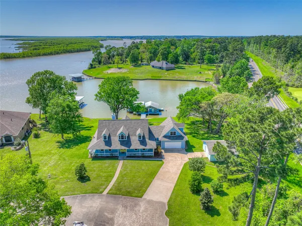 an aerial view of a house with a garden and lake view