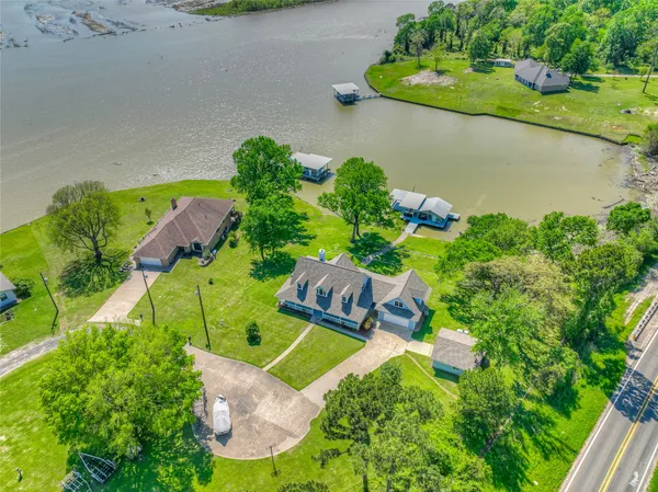 an aerial view of a house with a yard and lake view