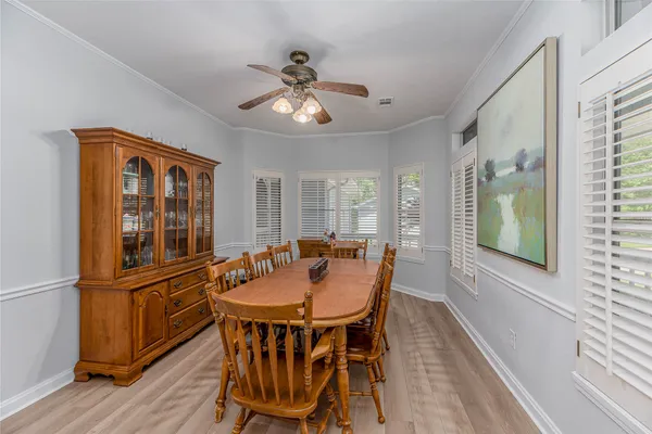 a dining room with furniture a chandelier and wooden floor