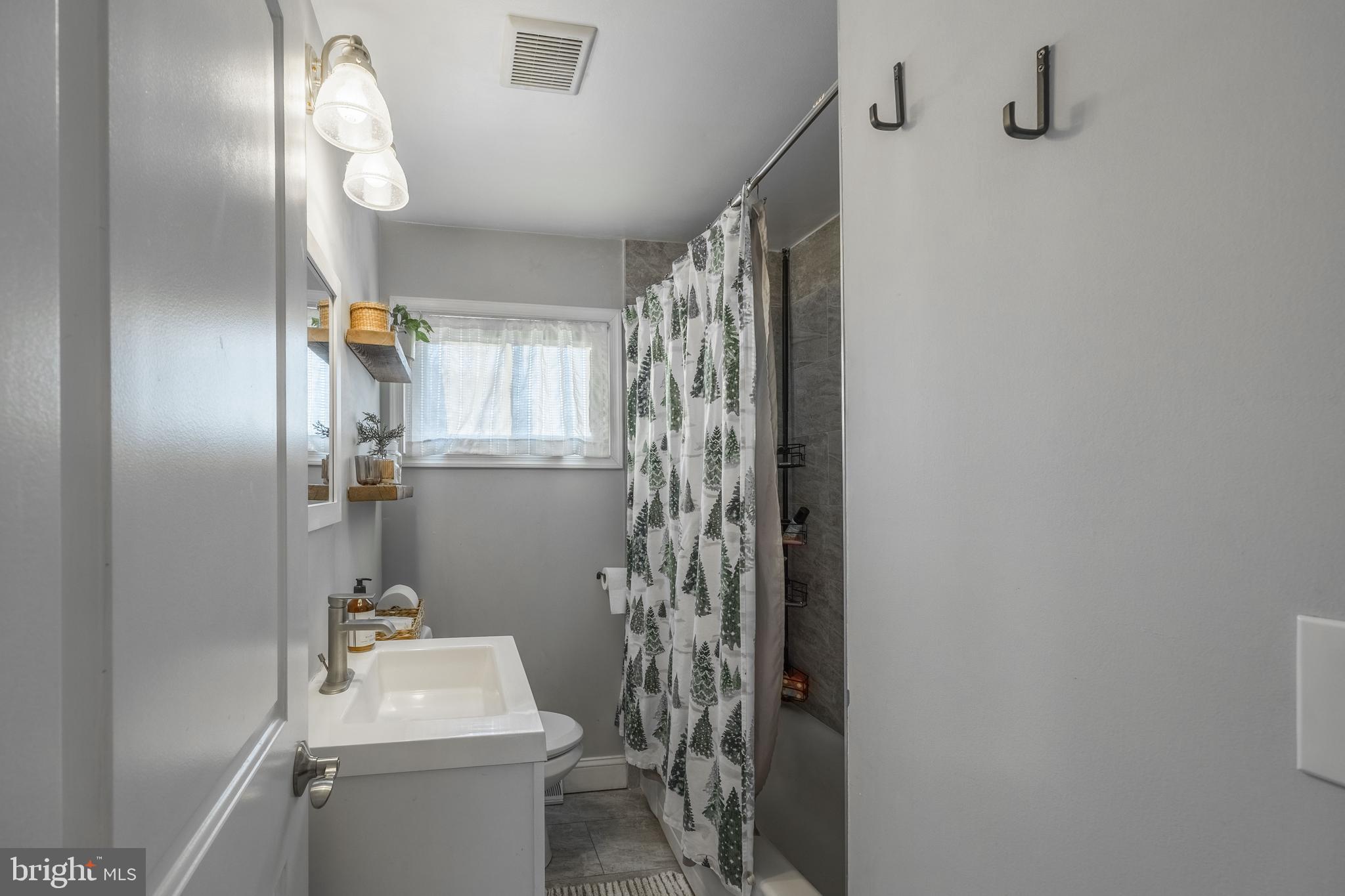 1001 Nancy Road Glen Burnie, MD 21061 - Photo 17 of 30 a bathroom with a toilet a sink and shower curtain