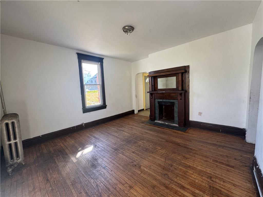 431 1st Street Allison, PA 15413 - Photo 5 of 15 an empty room with wooden floor a fireplace and windows