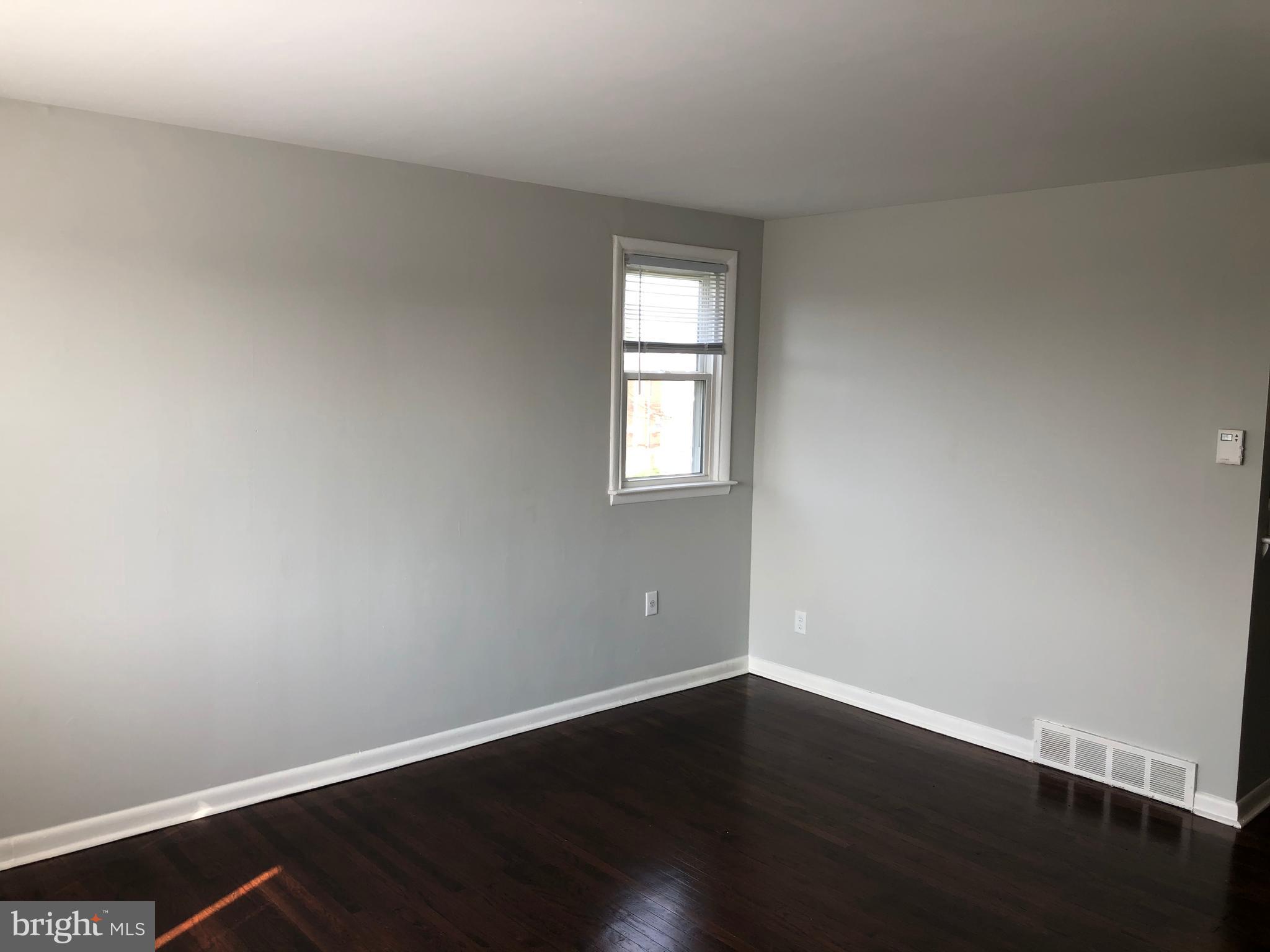 8726 Marsden Street Philadelphia, PA 19136 - Photo 20 of 24 a view of an empty room with wooden floor and a window