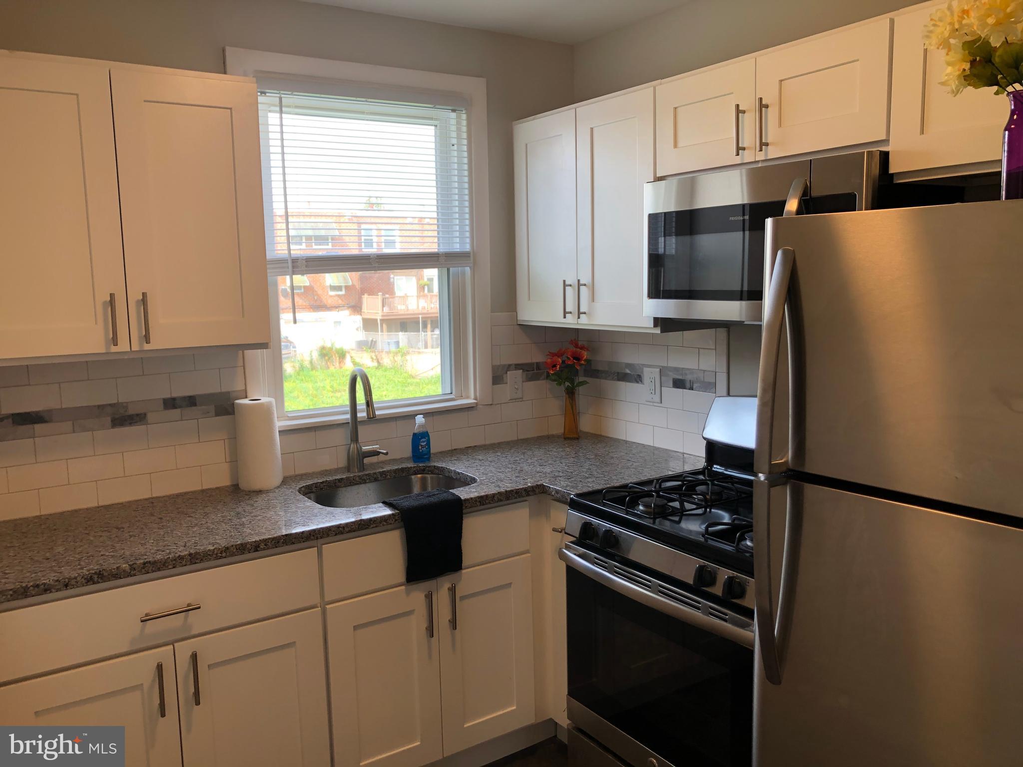 8726 Marsden Street Philadelphia, PA 19136 - Photo 10 of 24 a kitchen with stainless steel appliances granite countertop a sink stove refrigerator and cabinets