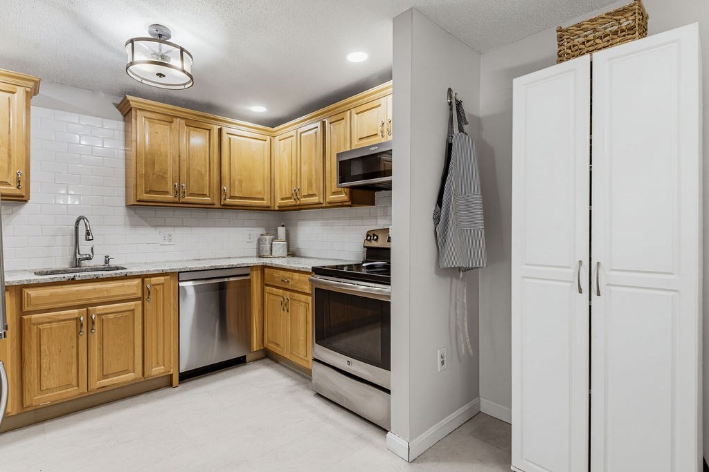 10 Erick Road, Unit 42 Mansfield, MA 02048 - Photo 13 of 33 a kitchen with stainless steel appliances granite countertop a refrigerator sink and stove