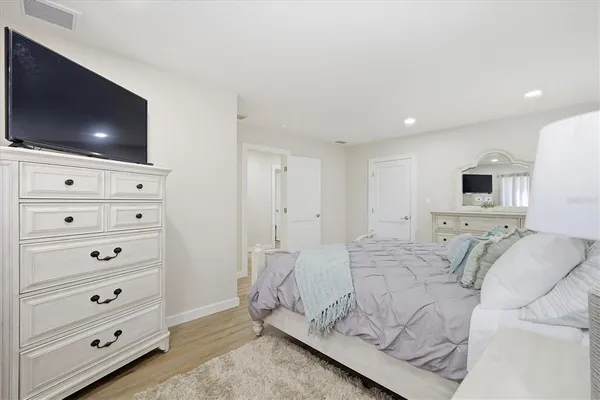 a spacious bedroom with a bed and a flat screen tv