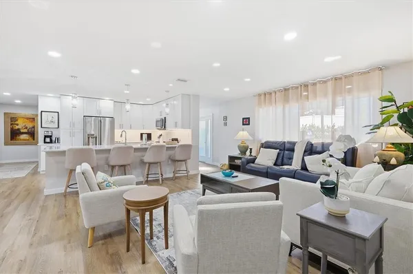 a living room with furniture kitchen and a table