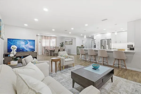 a living room with lots of furniture and kitchen view
