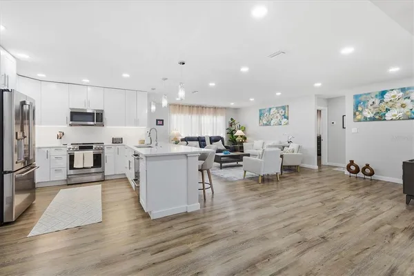 a kitchen with a sink cabinets and wooden floor
