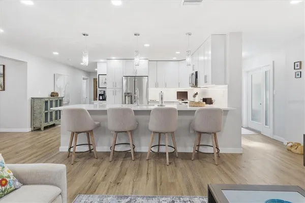 a dining room with stainless steel appliances furniture large window and wooden floor