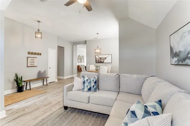 a living room with furniture and a wooden floor