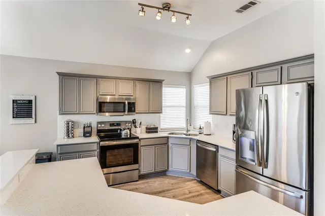 a kitchen with a sink stainless steel appliances and cabinets