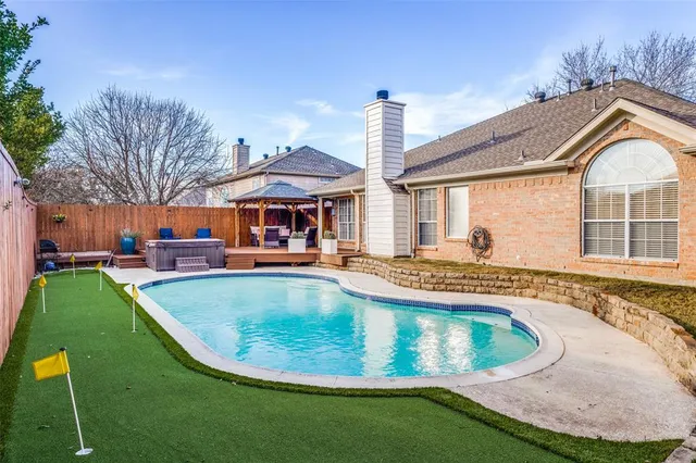 a view of a house with swimming pool and sitting area