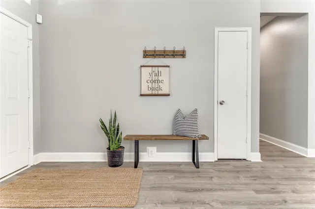 a view of a hallway with wooden floor and a potted plant