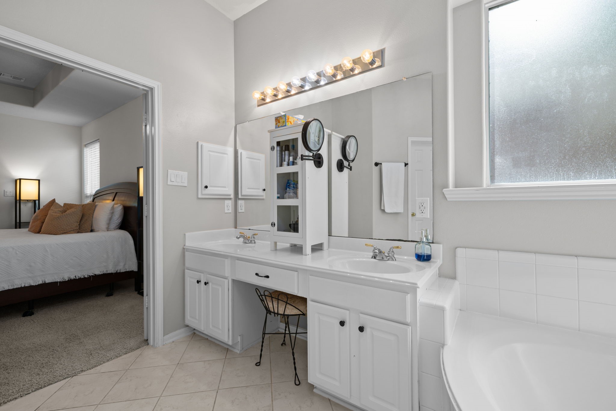 19114 Emory Trail Spring, TX 77388 - Photo 25 of 44 a en suite bathroom with a double vanity sink a mirror a vanity and bathtub