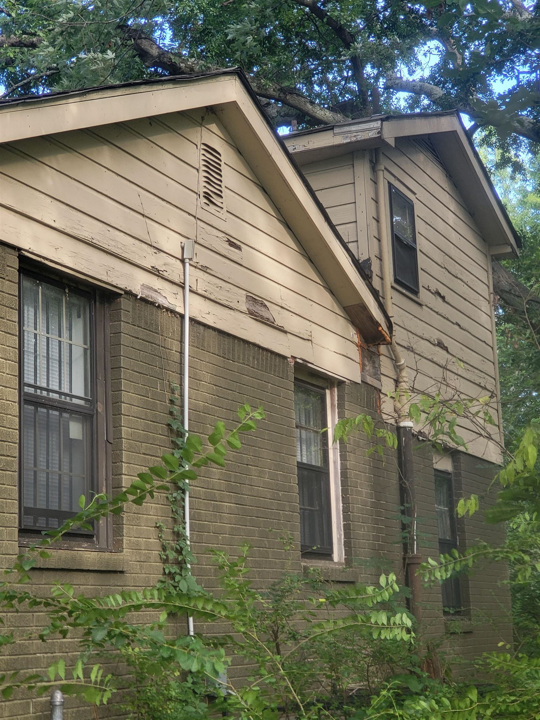 655 Granada Road Memphis, TN 38109 - Photo 3 of 5 a small white house with a white roof and table and chairs under an umbrella