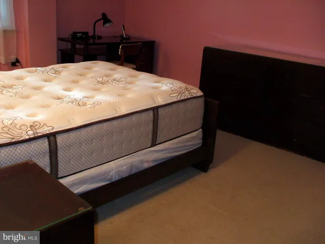 a bed sitting in a bedroom and bathroom