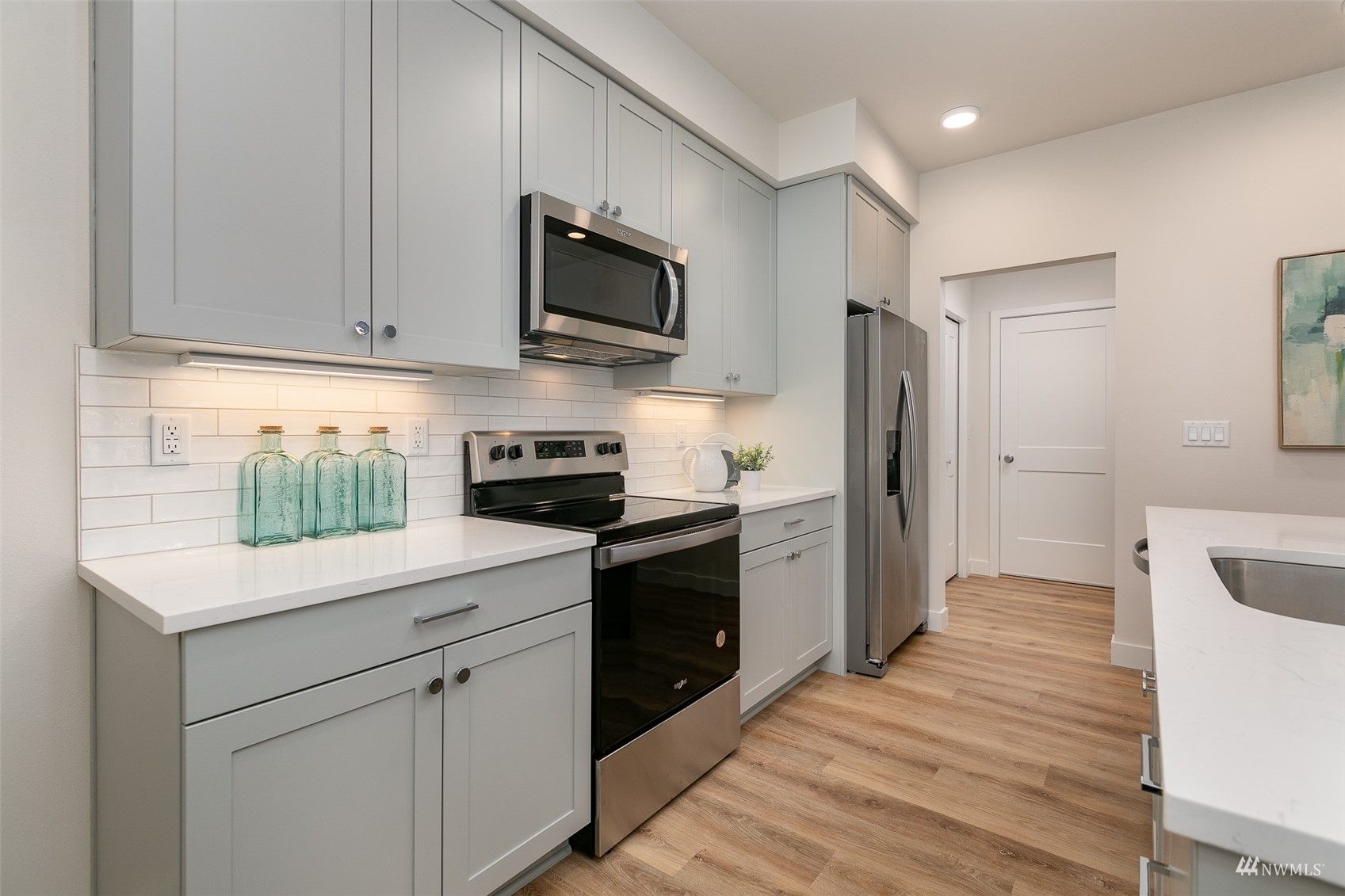 117 171st Place Southwest, Unit A Bothell, WA 98012 - Photo 10 of 20 a kitchen with white cabinets stainless steel appliances and a sink