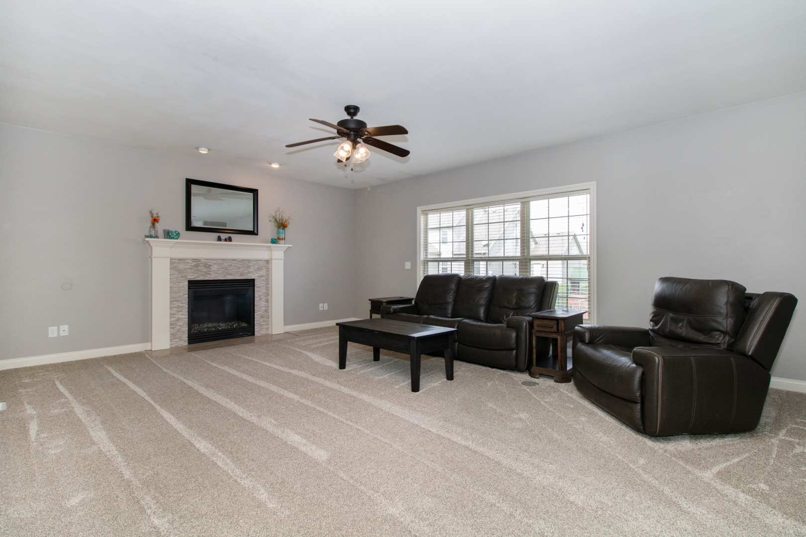 4002 Rockledge Road Bloomington, IL 61705 - Photo 12 of 60 a living room with furniture a fireplace and a flat screen tv