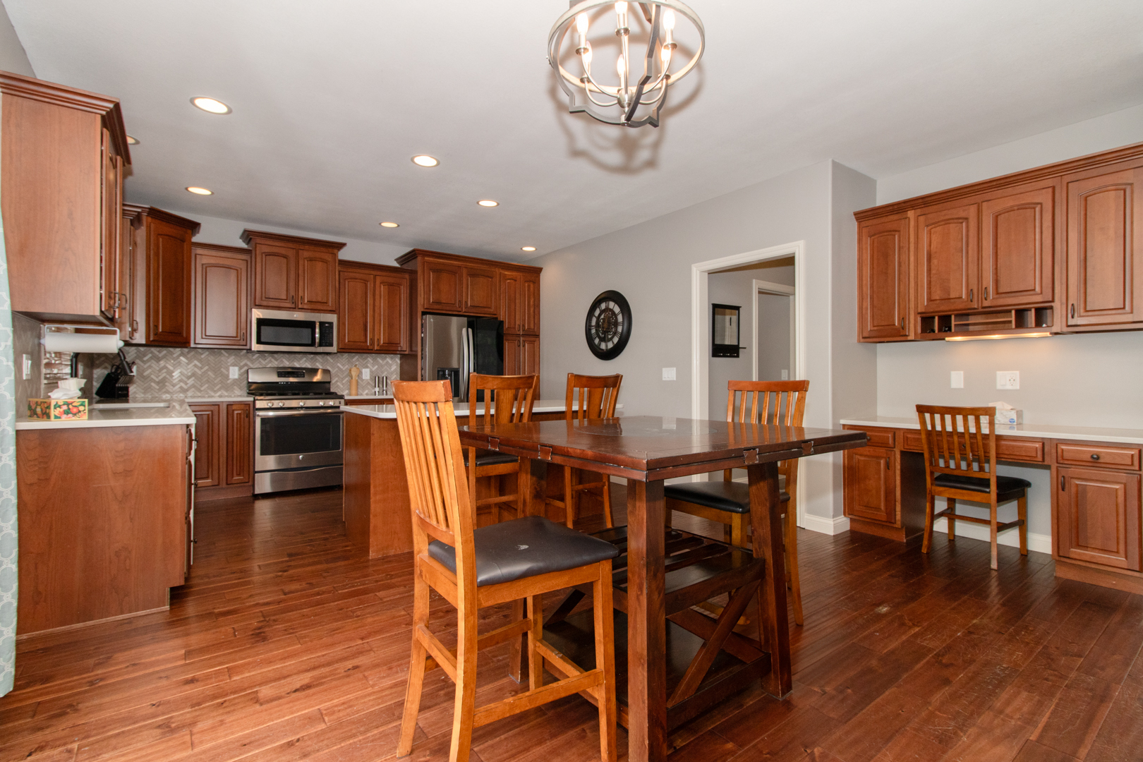 4002 Rockledge Road Bloomington, IL 61705 - Photo 18 of 60 a open kitchen with stainless steel appliances granite countertop a stove top oven a sink a dining table and chairs with wooden floor