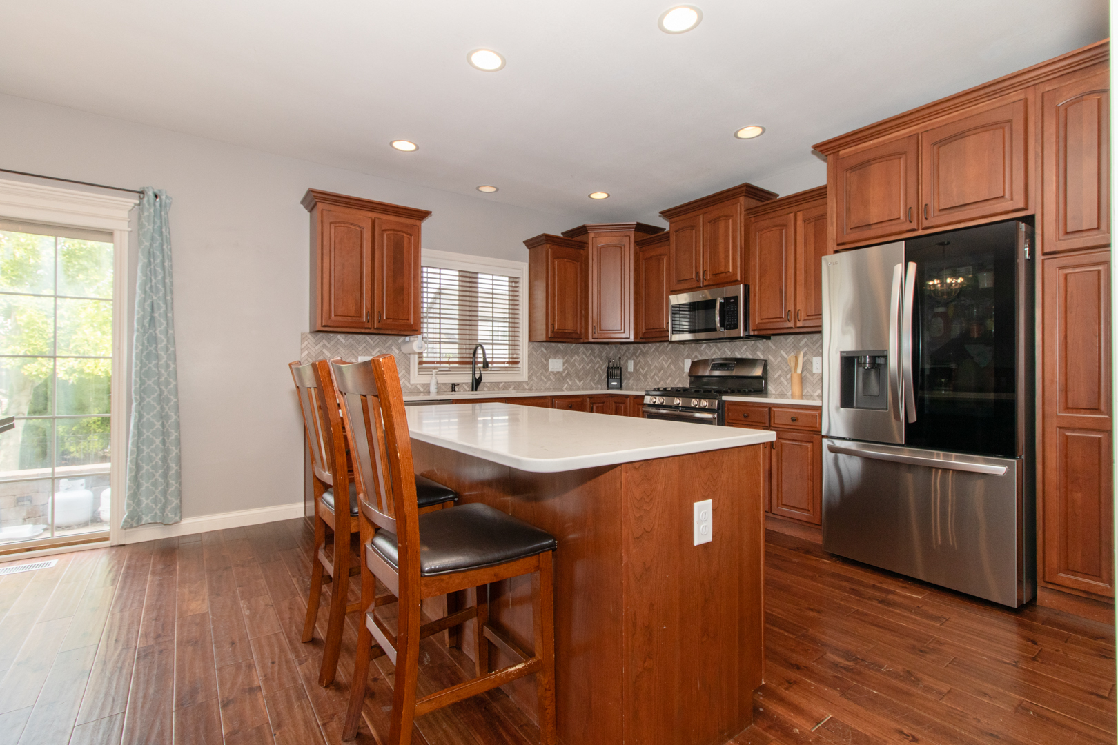 4002 Rockledge Road Bloomington, IL 61705 - Photo 21 of 60 a kitchen with stainless steel appliances granite countertop a refrigerator a stove top oven a sink dishwasher and wooden cabinets with wooden floor