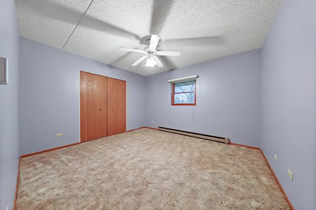 an empty room with windows and fan
