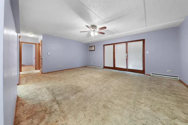 en empty room with windows and ceiling fan