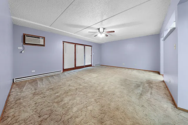 an empty room with windows and fan