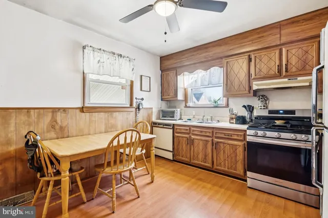 a kitchen with stainless steel appliances granite countertop a stove a sink dishwasher and cabinets with wooden floor