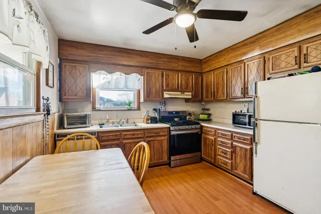 a kitchen with stainless steel appliances granite countertop a stove a sink and a white cabinets