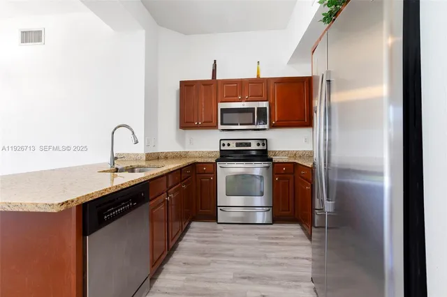 a kitchen with a sink and stainless steel appliances