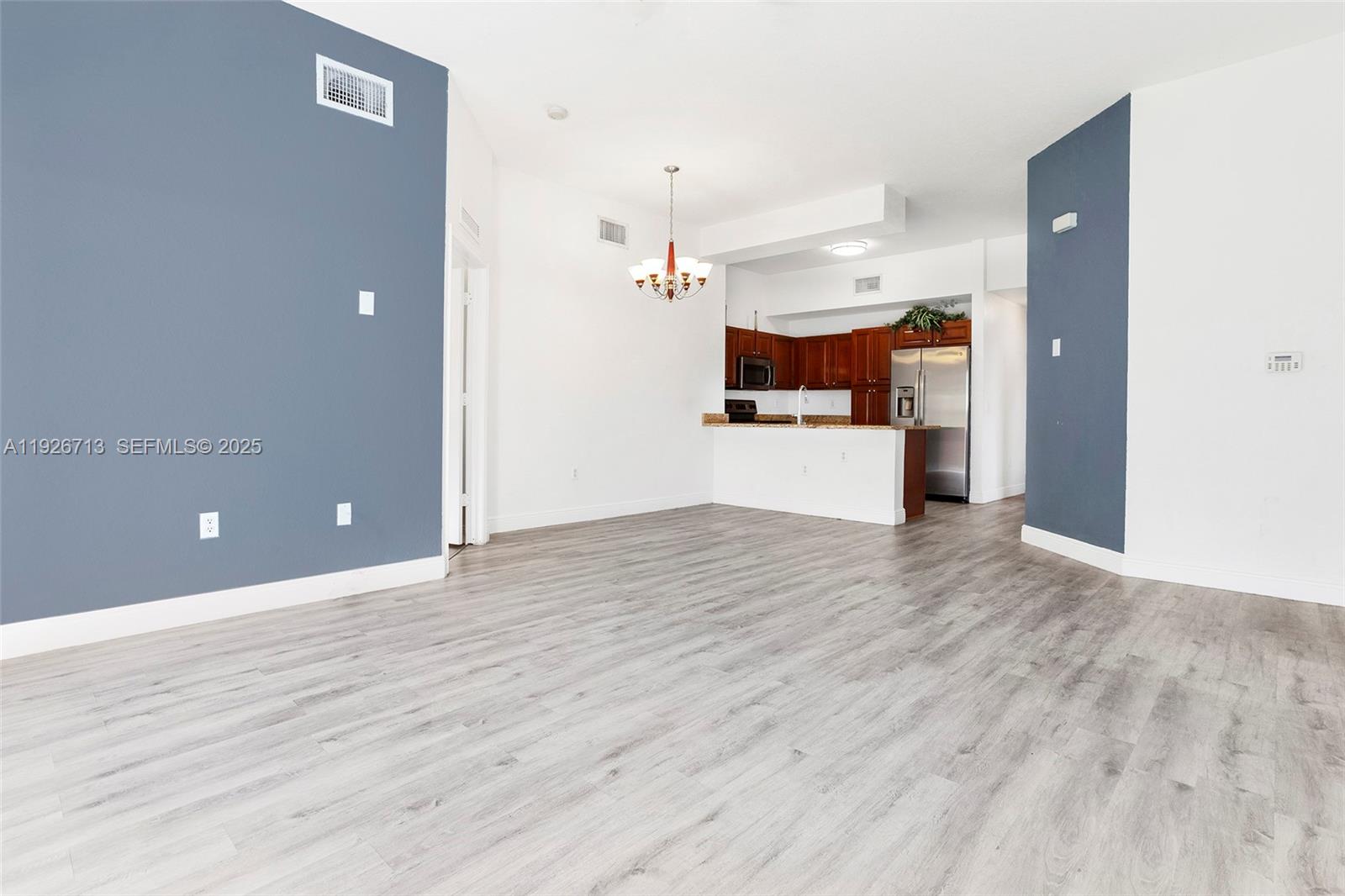 3340 Palomino Drive, Unit 2112 Davie, FL 33024 - Photo 6 of 25 an empty room with wooden floor and kitchen view
