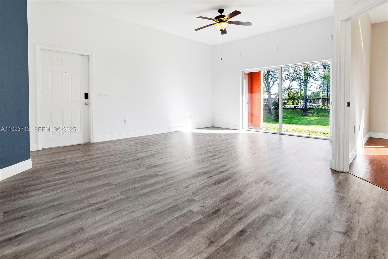 3340 Palomino Drive, Unit 2112 Davie, FL 33024 - Photo 9 of 25 a view of an empty room with wooden floor and a window