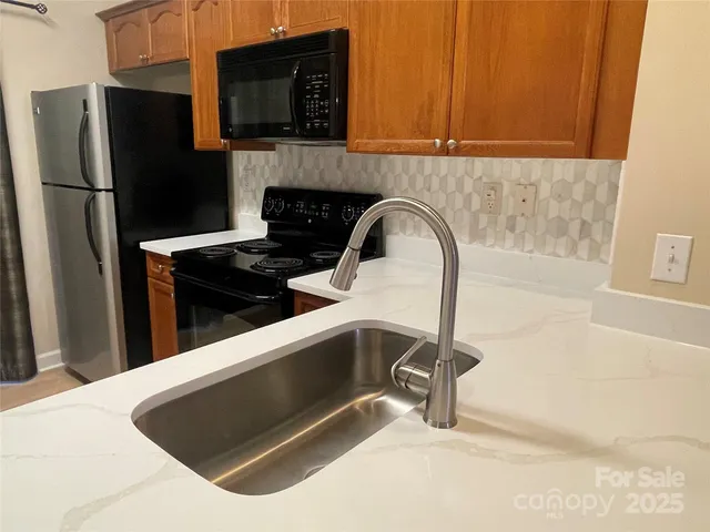 a kitchen with granite countertop a sink and cabinets