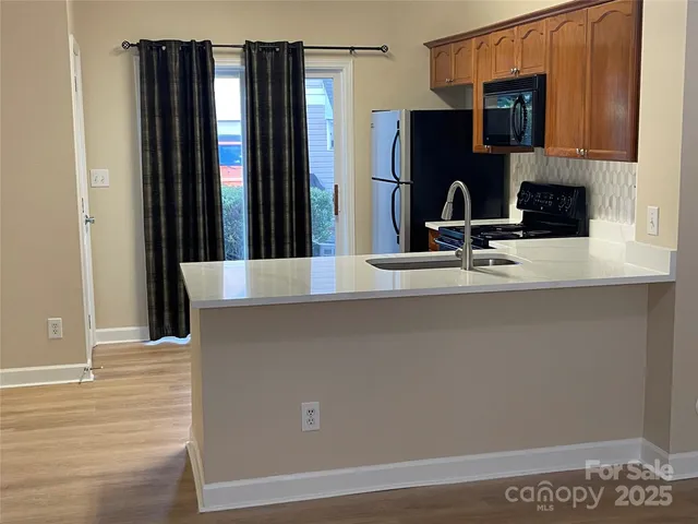 a kitchen with a sink a refrigerator and a microwave