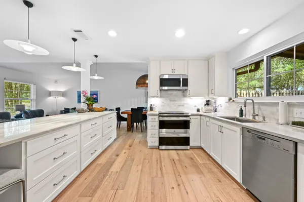 a kitchen with stainless steel appliances granite countertop a sink stove and wooden cabinets