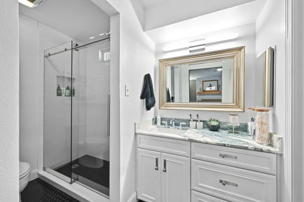 a bedroom with a bed a desk and chair next to a window