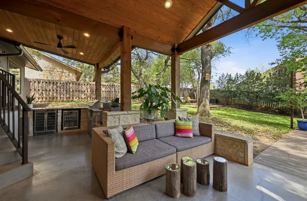 a view of backyard with large trees and wooden fence