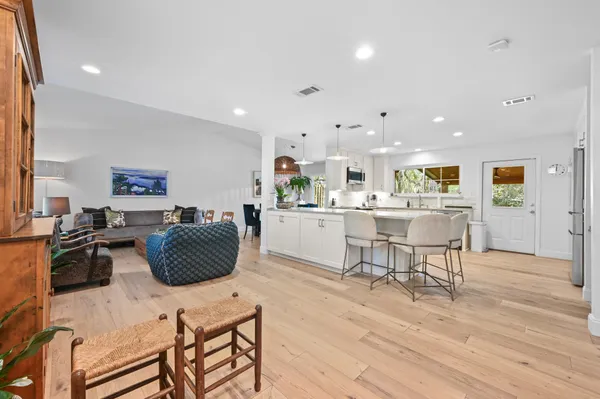 a living room with furniture a large window and wooden floor