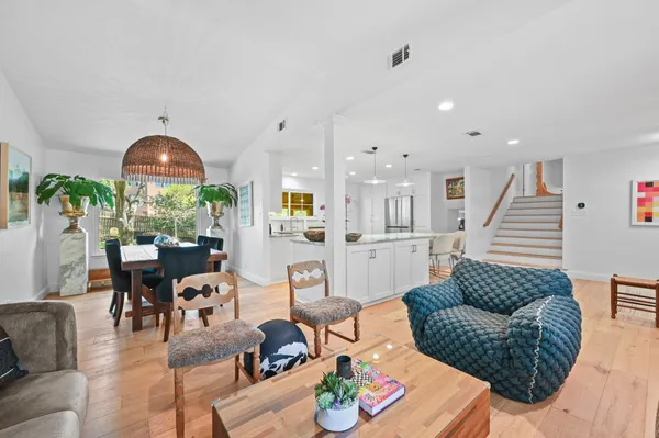 a large kitchen with stainless steel appliances kitchen island granite countertop a table chairs and a refrigerator