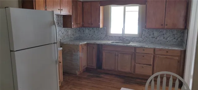 a kitchen with stainless steel appliances granite countertop a refrigerator sink and cabinets