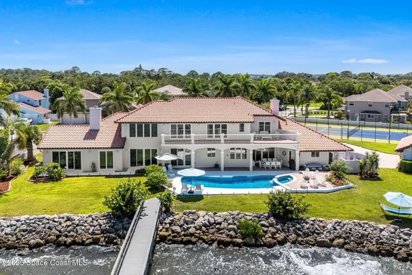 a living room with furniture wooden floor dining table and a large window