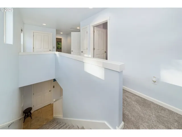 a view of kitchen with refrigerator and white cabinets