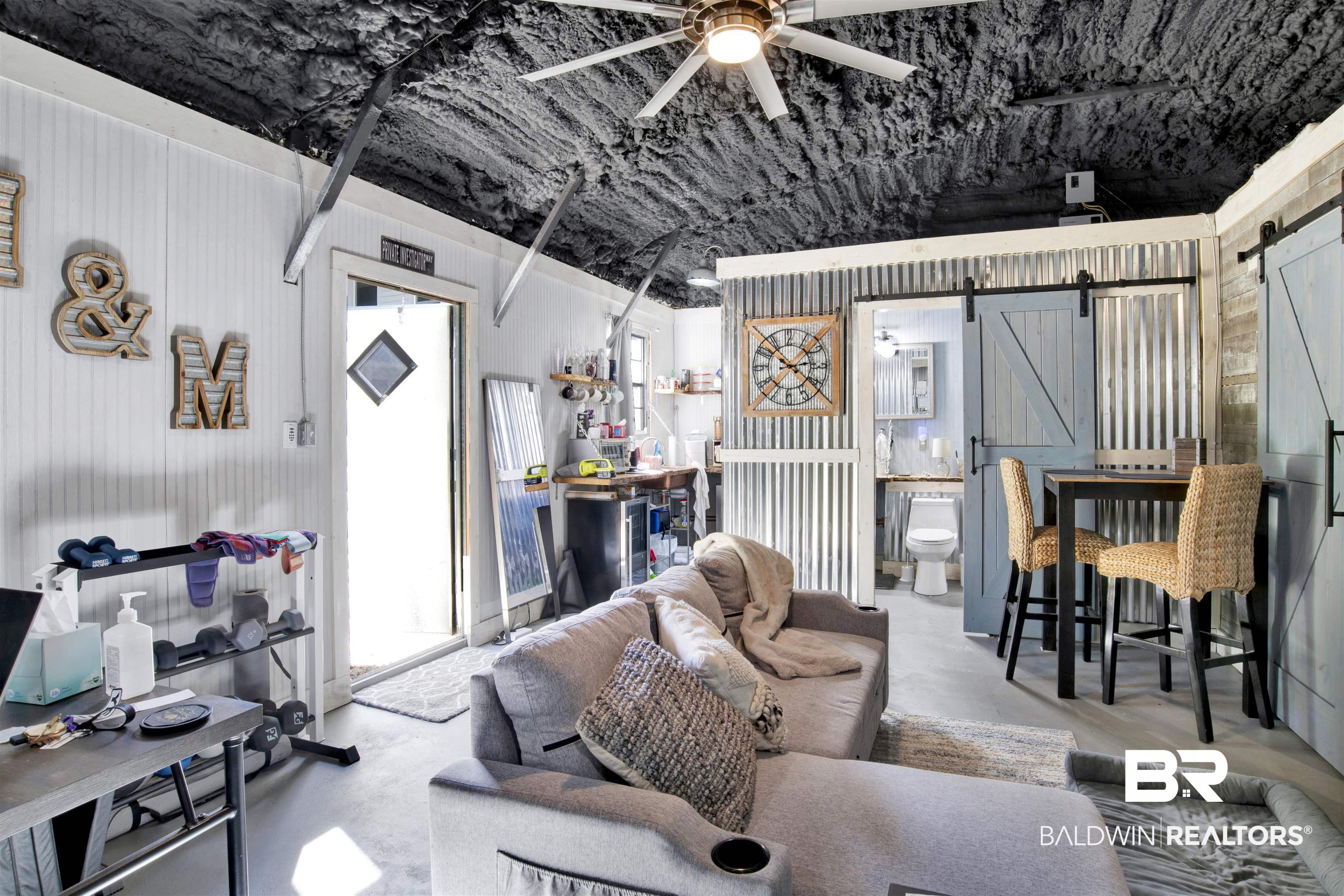 605 Van Avenue Daphne, AL 36526 - Photo 32 of 37 Living room featuring a barn door, concrete floors, and ceiling fan
