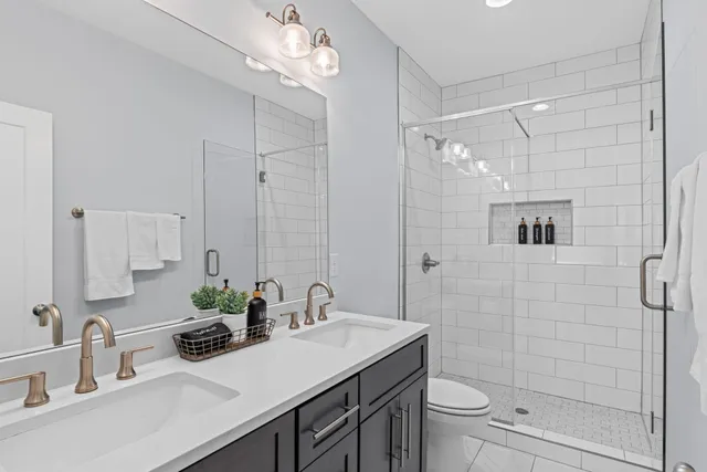 a bathroom with a sink a toilet and shower