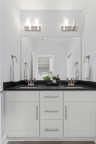 a bathroom with white cabinets and a sink