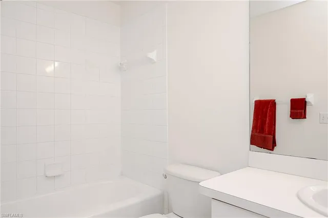 a white toilet sitting next to a white sink